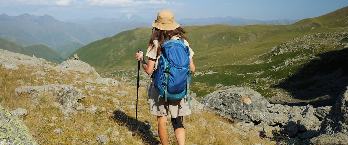 Žena s batohem a kloboukem na horské túře