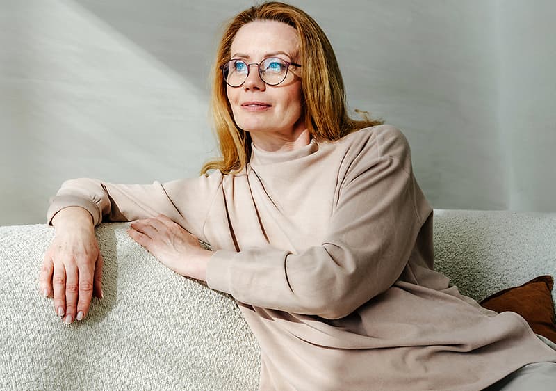 Žena sedí na gauči