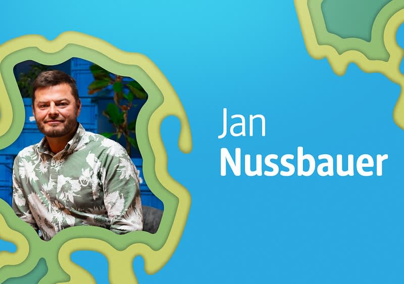 Osoba v květované košili na modrém pozadí s textem Jan Nussbauer