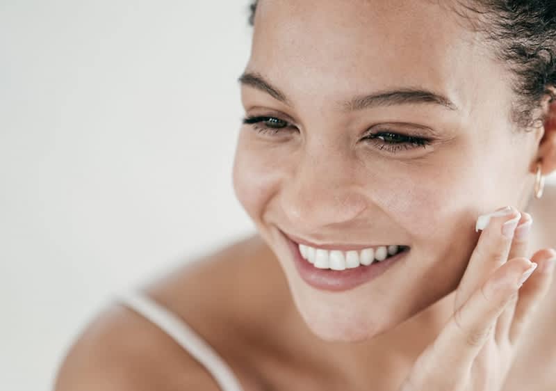 Žena s kudrnatými vlasy a náušnicí, rozmazaný obličej