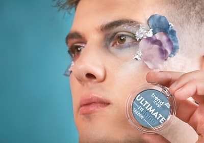 Ruka přidržující brýle na modrém pozadí