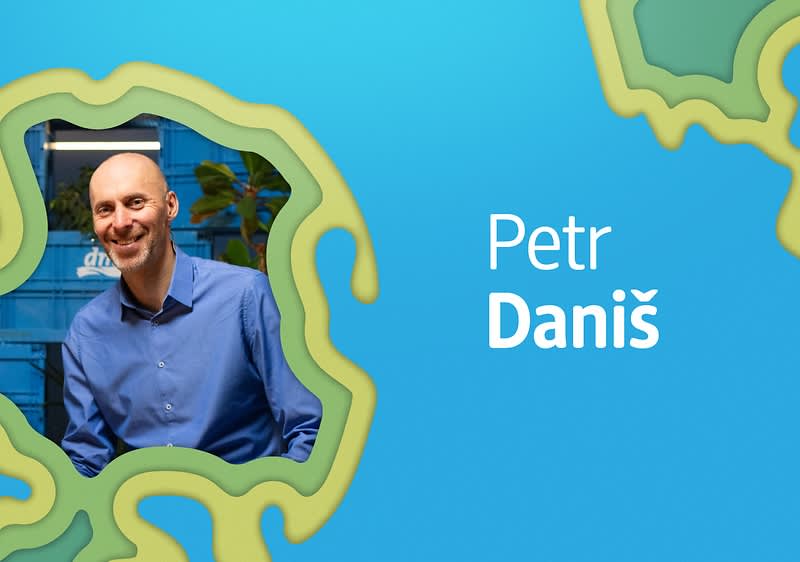 Modrý pozadí s textem Petr Daniš a rozmazanou osobou v modré košili