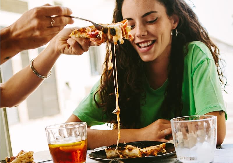 žena jí pizzu