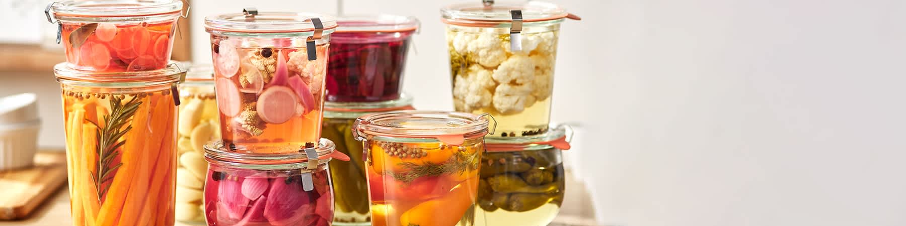 Sklenice s nakládanou zeleninou jako ředkvičky, řepa, květák, cibule a papriky