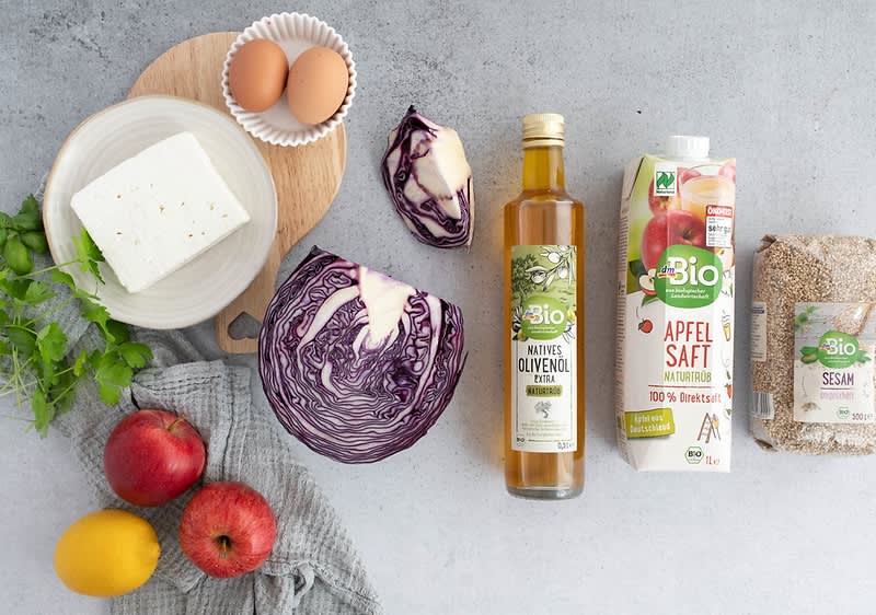 Ingredience na stole: vejce, feta, červené zelí, olivový olej, jablečný džus, sezam, jablka, citron, koriandr