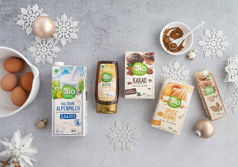 Bio potraviny na stole: mléko, med, kakao, škrob, vejce, koření, vánoční dekorace