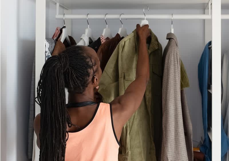 Žena vybírající oblečení ze skříně