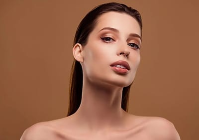 Žena s dlouhými hnědými vlasy na hnědém pozadí