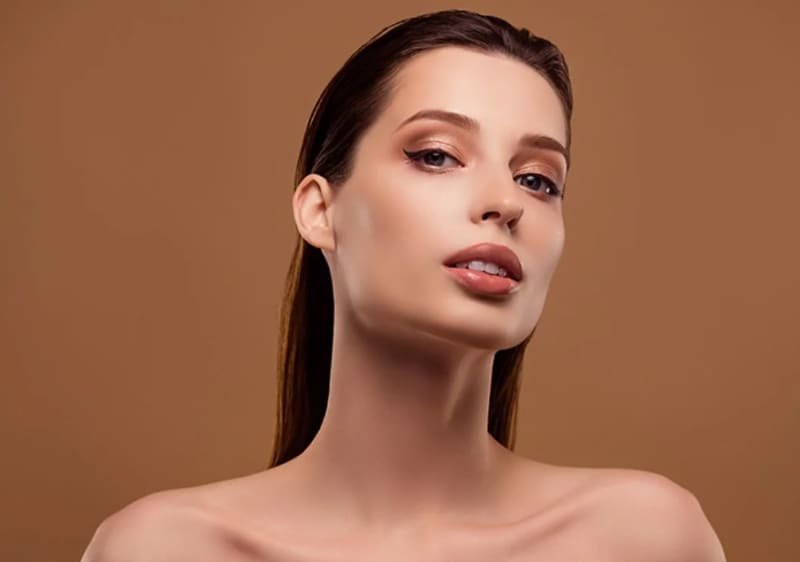 Žena s dlouhými hnědými vlasy na hnědém pozadí