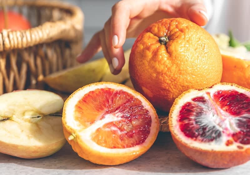 rozkrojený pomeranče a jablka na stole