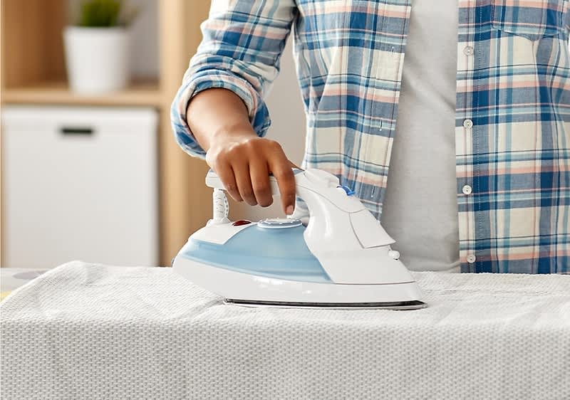 Žena žehlí prádlo