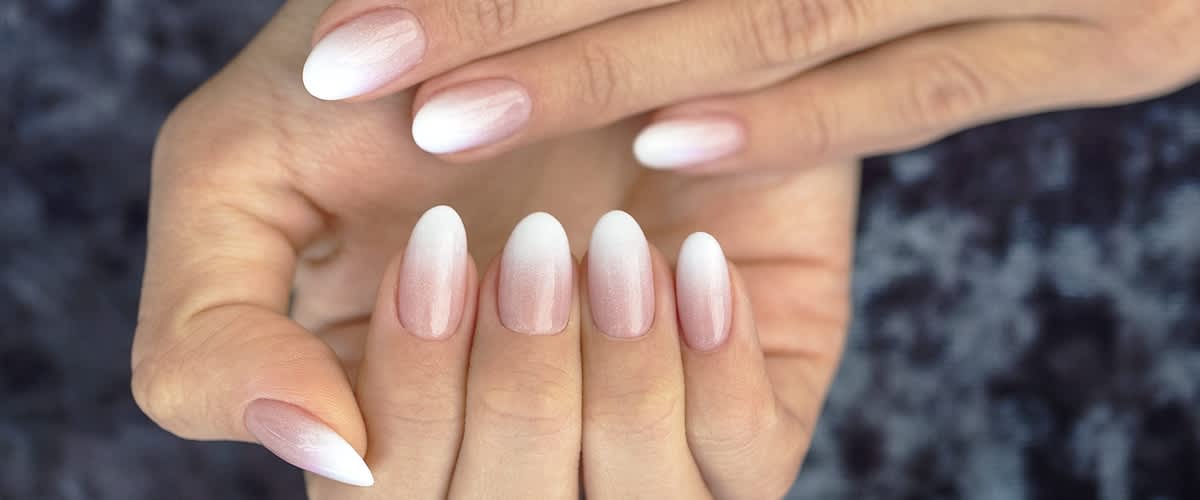 Ruce s jemně růžovo-bílou ombré manikúrou na nehtech