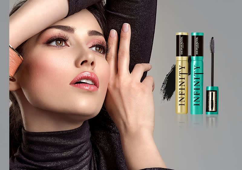 Ruka modelky, dvě řasenky Infinity v zeleném a zlatém obalu