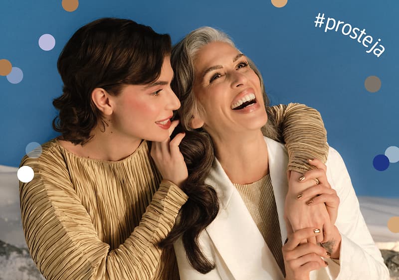 Dvě ženy v elegantním oblečení na modrém pozadí s hashtagem #prosteja