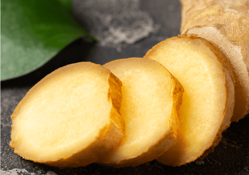 Plátky čerstvého zázvoru na tmavém povrchu