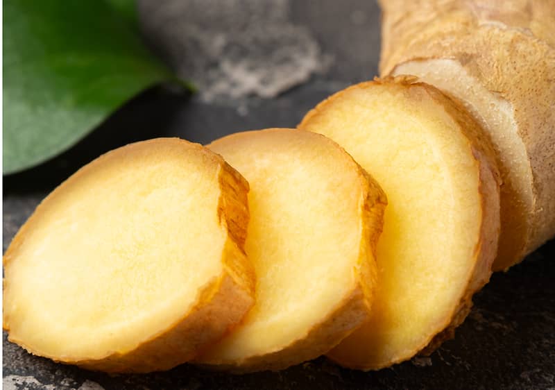 Plátky čerstvého zázvoru na tmavém povrchu