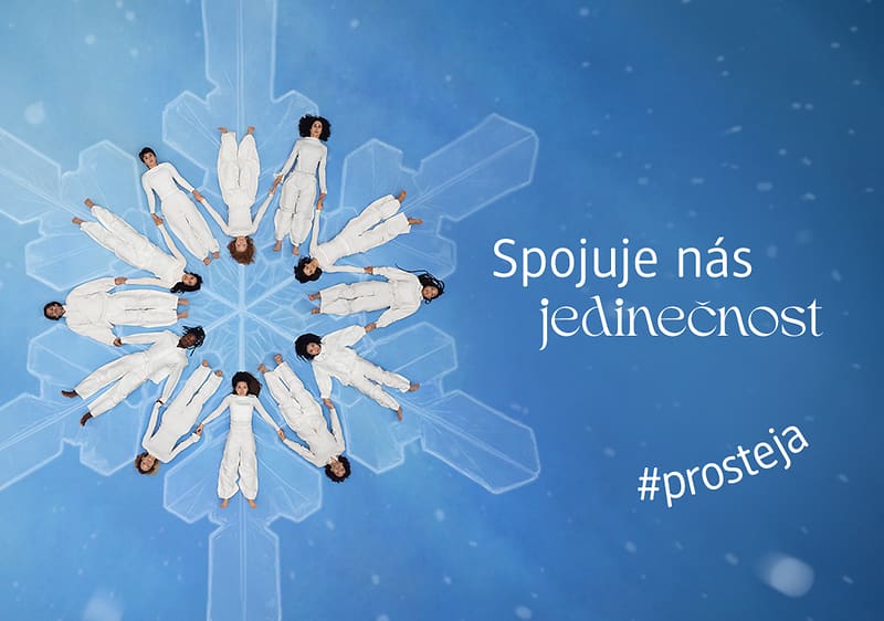 Lidé v bílém na sněhové vločce s textem Spojuje nás jedinečnost a #prosteja