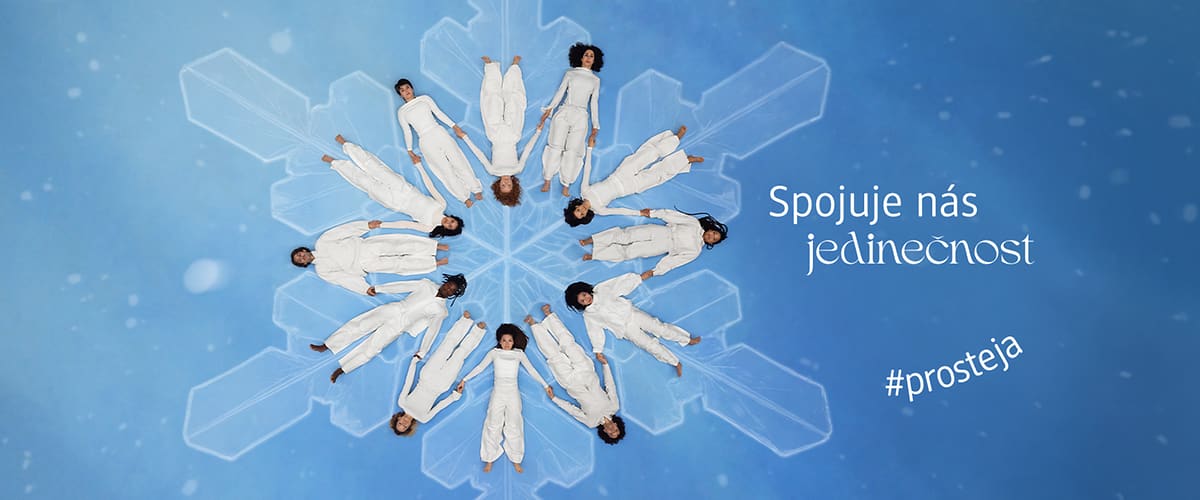 Lidé v bílém na sněhové vločce s textem Spojuje nás jedinečnost a #prosteja