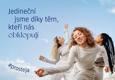 Tři ženy v bílém tančí na modrém pozadí s textem o jedinečnosti