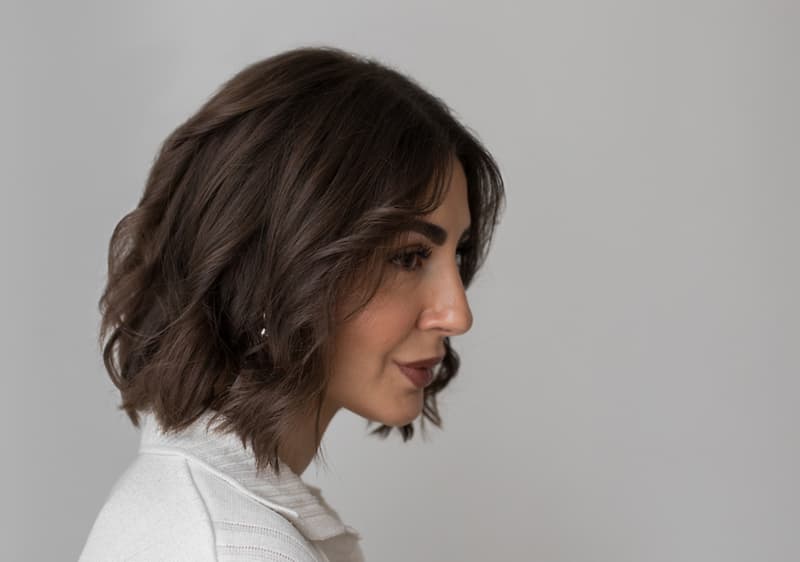Žena s beach waves v bílém oblečení