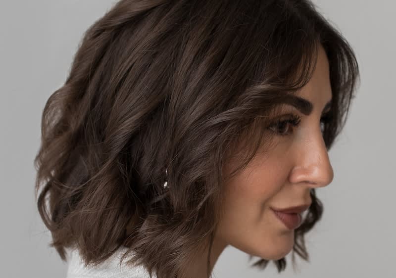 Žena s beach waves v bílém oblečení