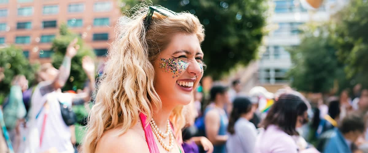 Žena s dlouhými světle blond vlasy a festivalovým líčením v davu na venkovní akci
