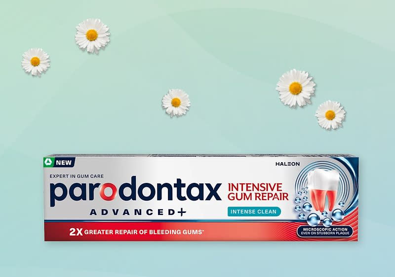 Krabice zubní pasty Parodontax Intensive Gum Repair na světle zeleném pozadí s kopretinami