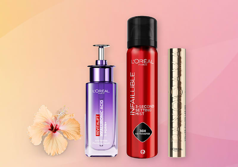 Kosmetické produkty L'Oréal na růžovo-oranžovém pozadí s květem ibišku