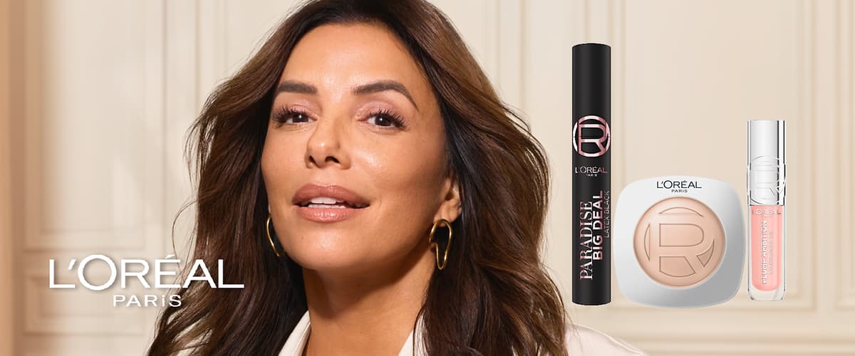 Usmívající se dospělá žena v poloprofilu s volnými tmavými vlasy a zlatými kruhovými náušnicemi, vedle ní tři produkty L'Oréal: černé balení řasenky s nápisem „PARADISE BIG DEAL“, čtvercové pudrové kompaktní balení s logem „L'ORÉAL“ a průhledný lesk na rty s růžovým odstínem a stříbrným víčkem