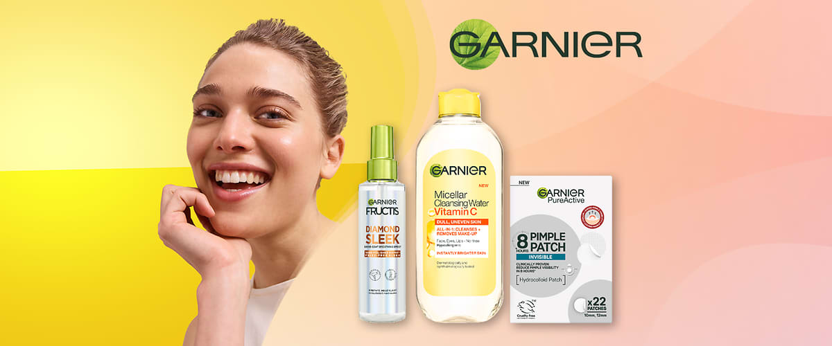 Usmívající se žena s jemným make-upem v levé části obrazu a vpravo vedle ní tři produkty Garnier: sprej Fructis Diamond Sleek, lahvička Micellar Cleansing Water Vitamin C s žlutým víčkem a bílé balení Garnier Pure Active Pimple Patch s nápisem „x22“ a logem Garnier