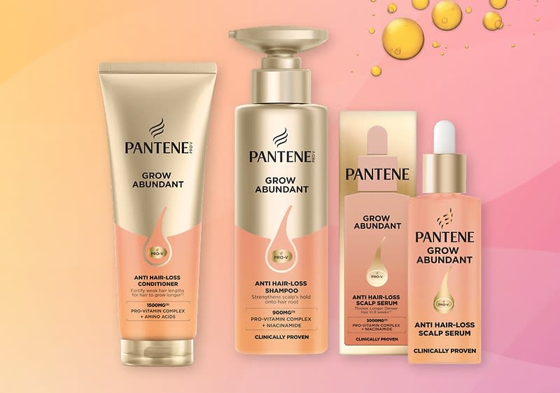 Čtyři zlatavě růžové produkty Pantene Grow Abundant: kondicionér v tubě, pumpovatelný šampon, krabička s ampulí a kapátkový sérum proti vypadávání vlasů s nápisy „ANTI HAIR-LOSS“ a „GROW ABUNDANT“ na obalech