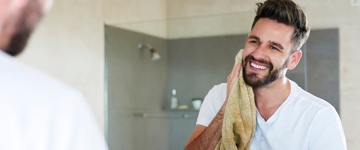 Muž v bílé košili v koupelně.