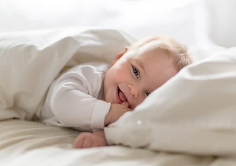 Spící dítě pod bílou přikrývkou