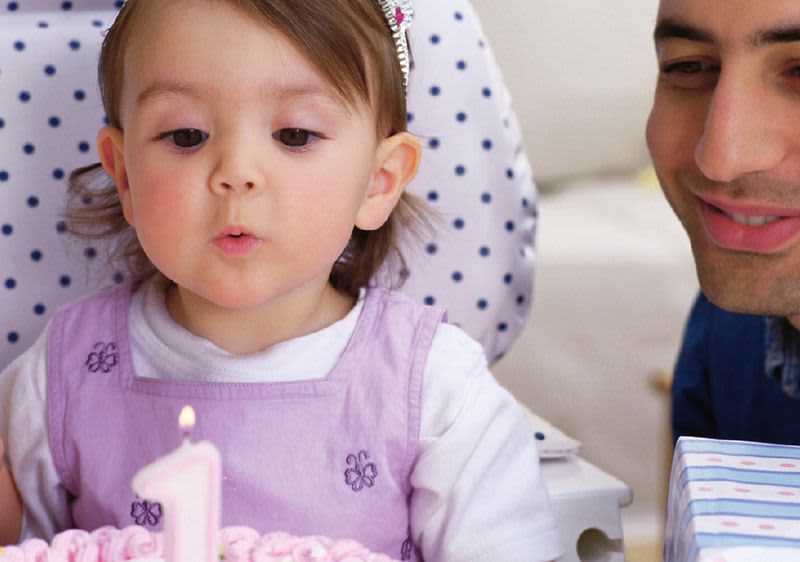 Dítě v židličce s narozeninovým dortem - první narozeniny