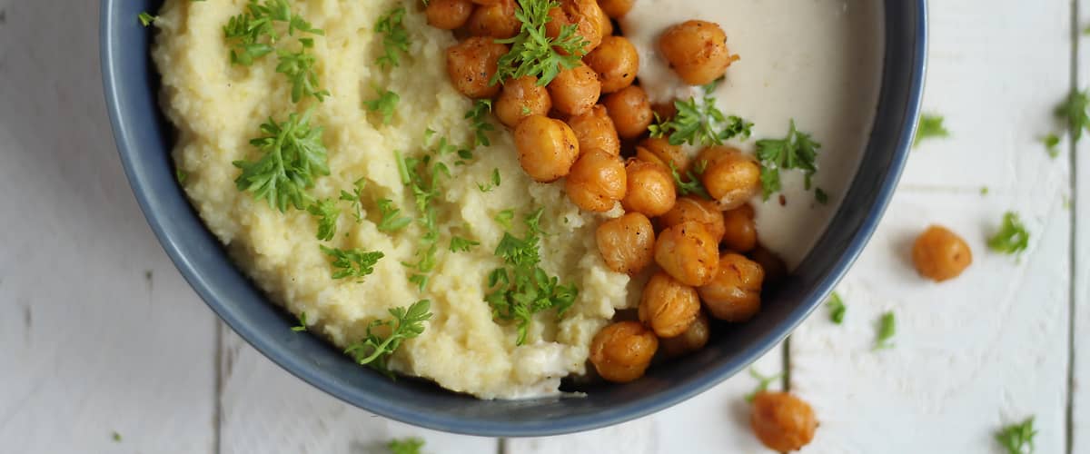 Miska s kaší, cizrnou a petrželkou na dřevěném stole