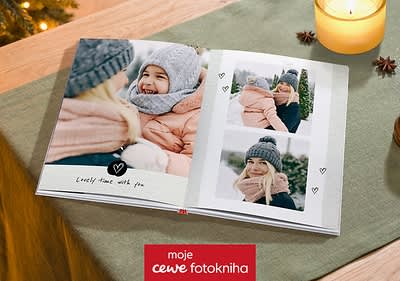 Fotokniha s fotografiemi ženy v zimním oblečení a svíčka na stole