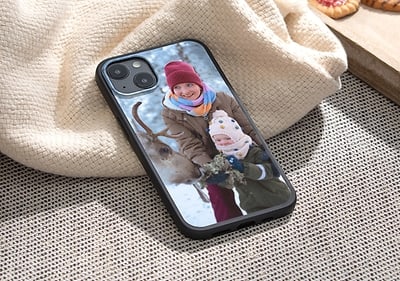 Mobilní telefon s obalem zobrazujícím dítě s jelenem na sněhu