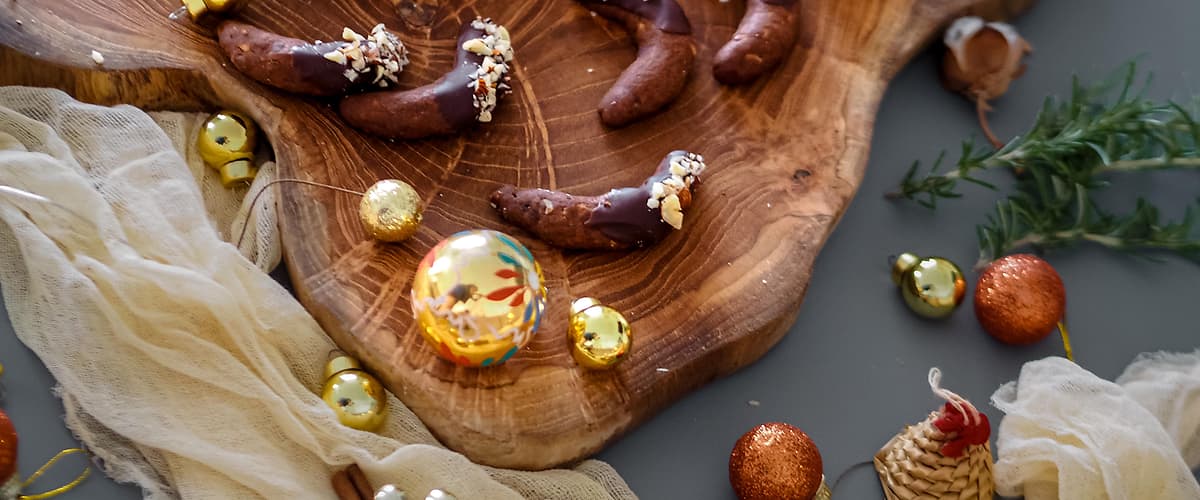 Vánoční cukroví na dřevěném prkénku s ozdobami a sušeným pomerančem