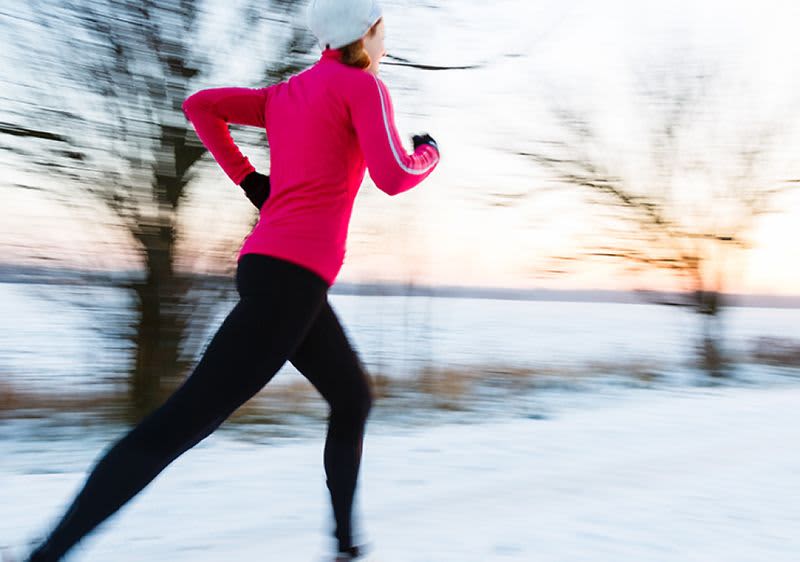 Žena běží venku v zimě