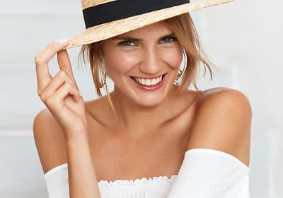 Žena v bílém topu s kloboukem na hlavě