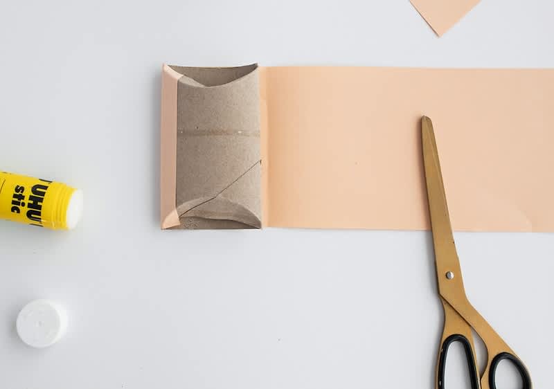 Výroba dekorace s nůžkami a lepidlem na stole