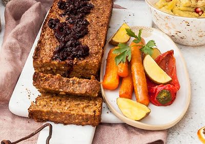 Vegetariánská sekaná s brusinkami, pečená zelenina a brambory na talíři