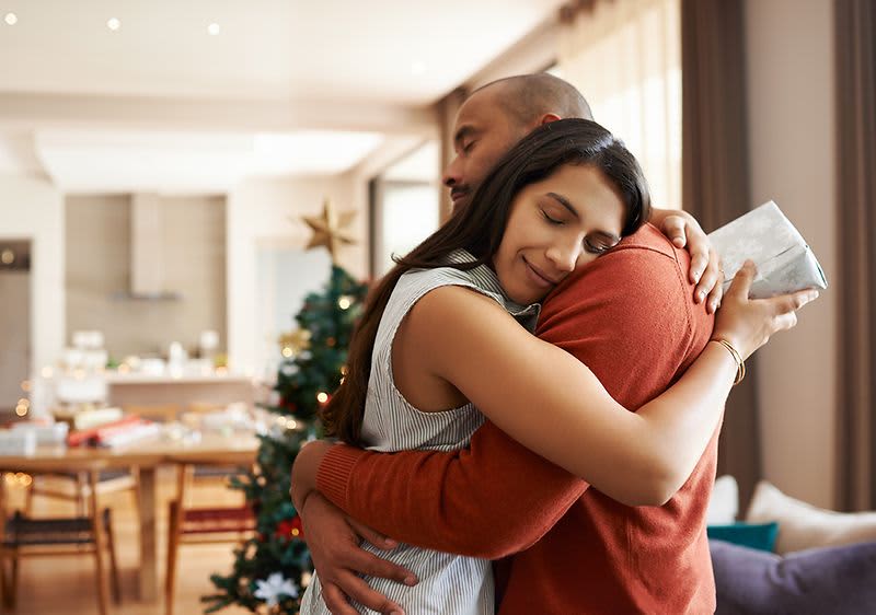 Objímání u vánočního stromku v obývacím pokoji