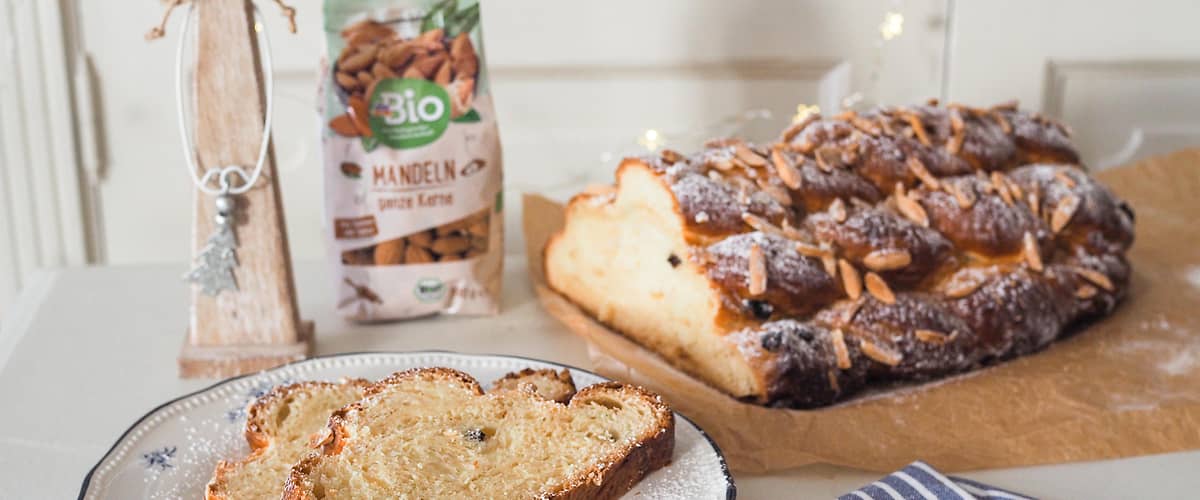 Vánočka na talíři, balení mandlí, dřevěná dekorace s jelenem, pruhovaný ubrus