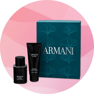 Eine dunkelgrüne Geschenkbox mit geprägten Blättern enthält ein schwarzes Parfümfläschchen und eine schwarze Tube mit der Aufschrift „Armani Code“