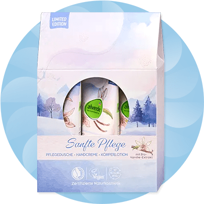Eine Geschenkbox mit winterlichem Design enthält drei Alverde-Produkte, darunter Pflegedusche, Handcreme und Körperlotion mit Bio-Vanille-Extrakt, die Verpackung zeigt eine verschneite Landschaft und die Aufschrift „Sanfte Pflege“