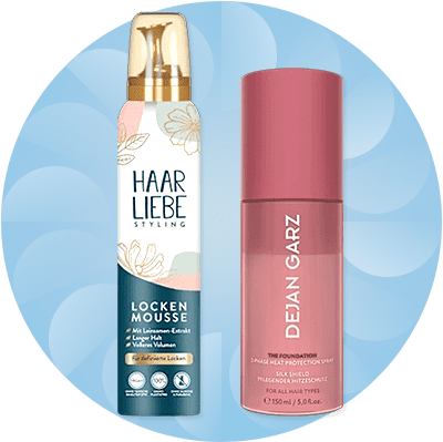 Eine Flasche Haarliebe Lockenmousse mit Blumenmuster neben einer rosa Flasche Dejan Garz Hitzeschutzspray
