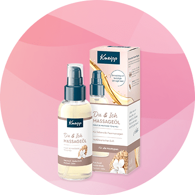 Eine Flasche Kneipp Massageöl mit Verpackung, Aufschrift „Du & Ich Massageöl“ und „Verwöhnender Duft“ auf rosa Hintergrund