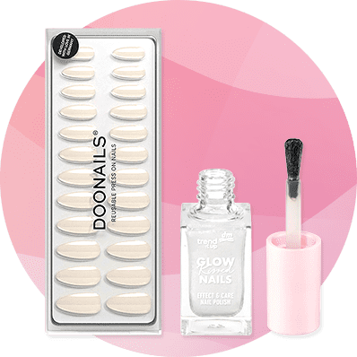 Eine Packung Doonails mit wiederverwendbaren Nagelspitzen und eine geöffnete Flasche Glow-Kissed Nails von trend IT UP vor einem rosa Hintergrund