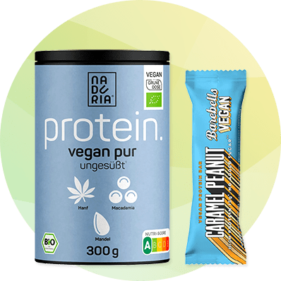 Blaue Dose mit Aufschrift „protein. vegan pur ungesüßt“ und Symbole für Hanf, Macadamia und Mandel neben einer hellblauen Riegelverpackung mit Aufschrift „CARAMEL PEANUT“ und „VEGAN“